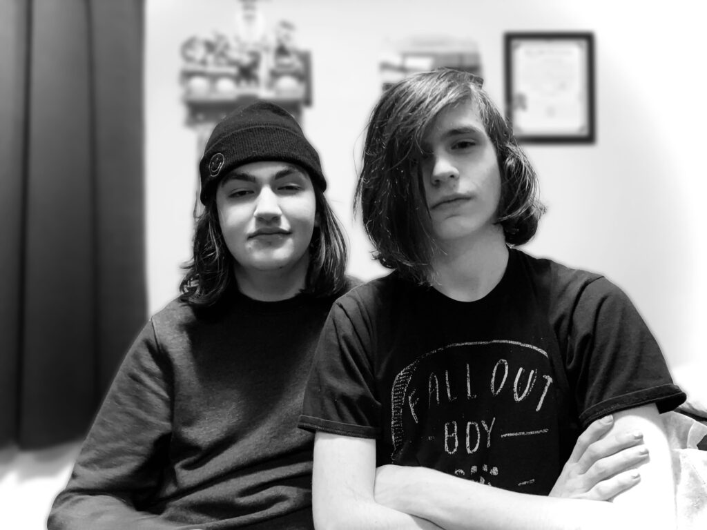 Cameron and Antonio in their 2022 era. They are sitting in a room, posing for the camera.