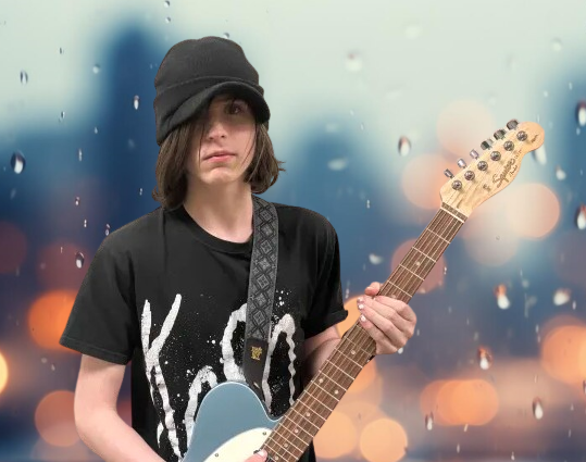 Antonio holding a guitar with a blurred background.